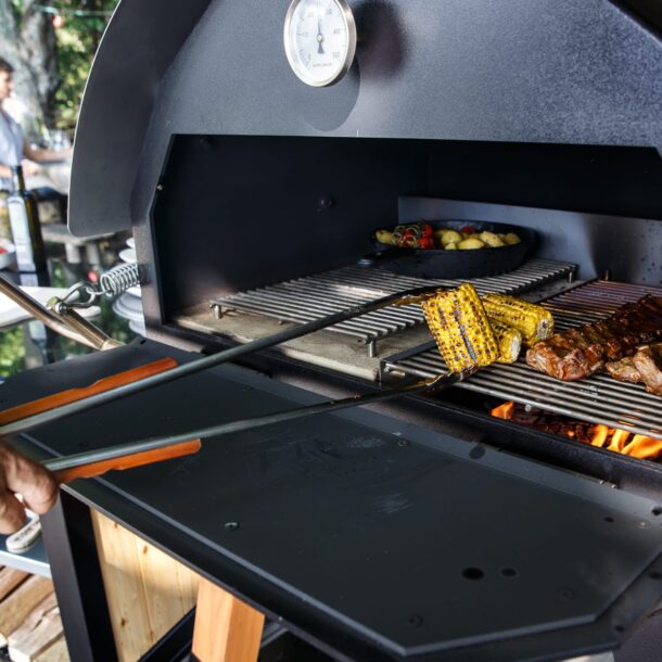 Merklinger wood-fired oven Grill Pizza oven Bread oven XXL Grill tongs in use for grilling corn